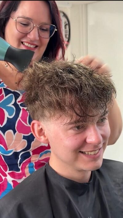 Flavien heureux de son complément capillaire avec Sabrina en arrière-plan lors de la mise en beauté – Capillexpert